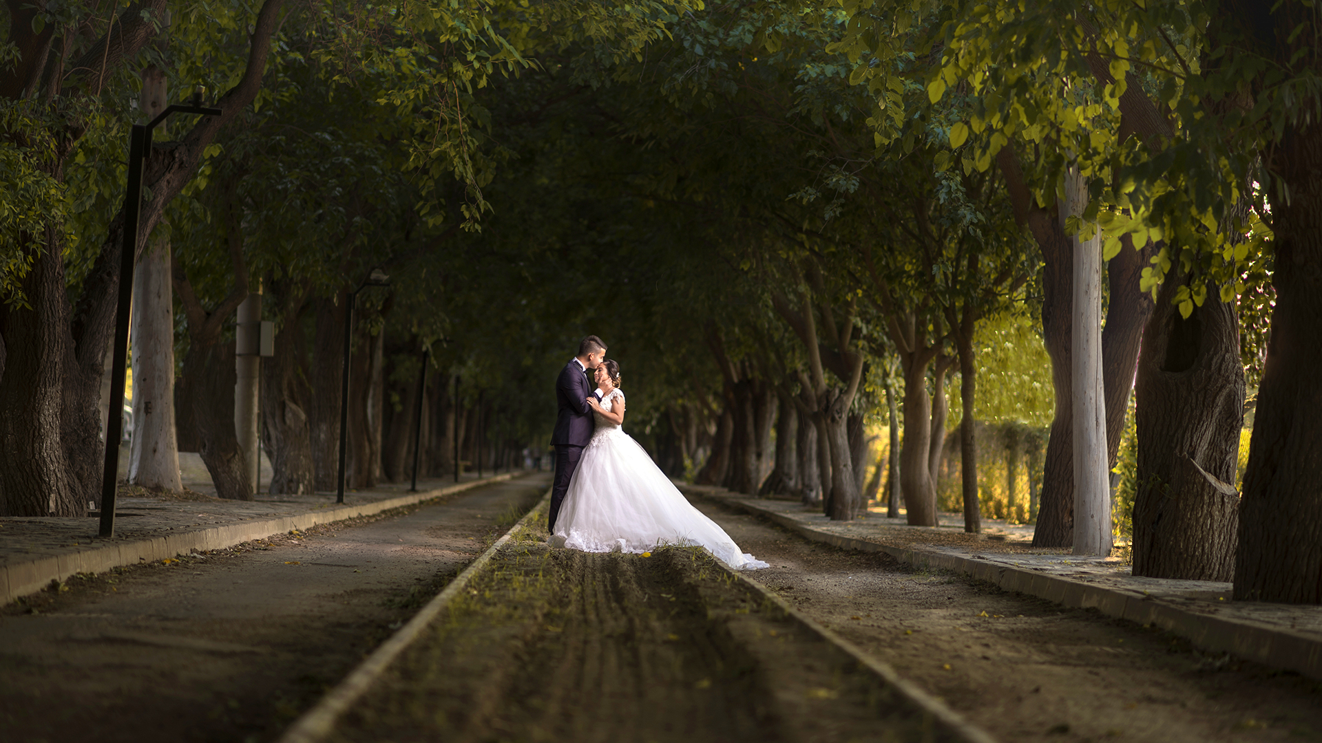 Blog 3 A breathtaking aerial drone shot of a couple standing on a 15th-century bridge, capturing the perfect cinematic wedding film Essex at Prested Hall.